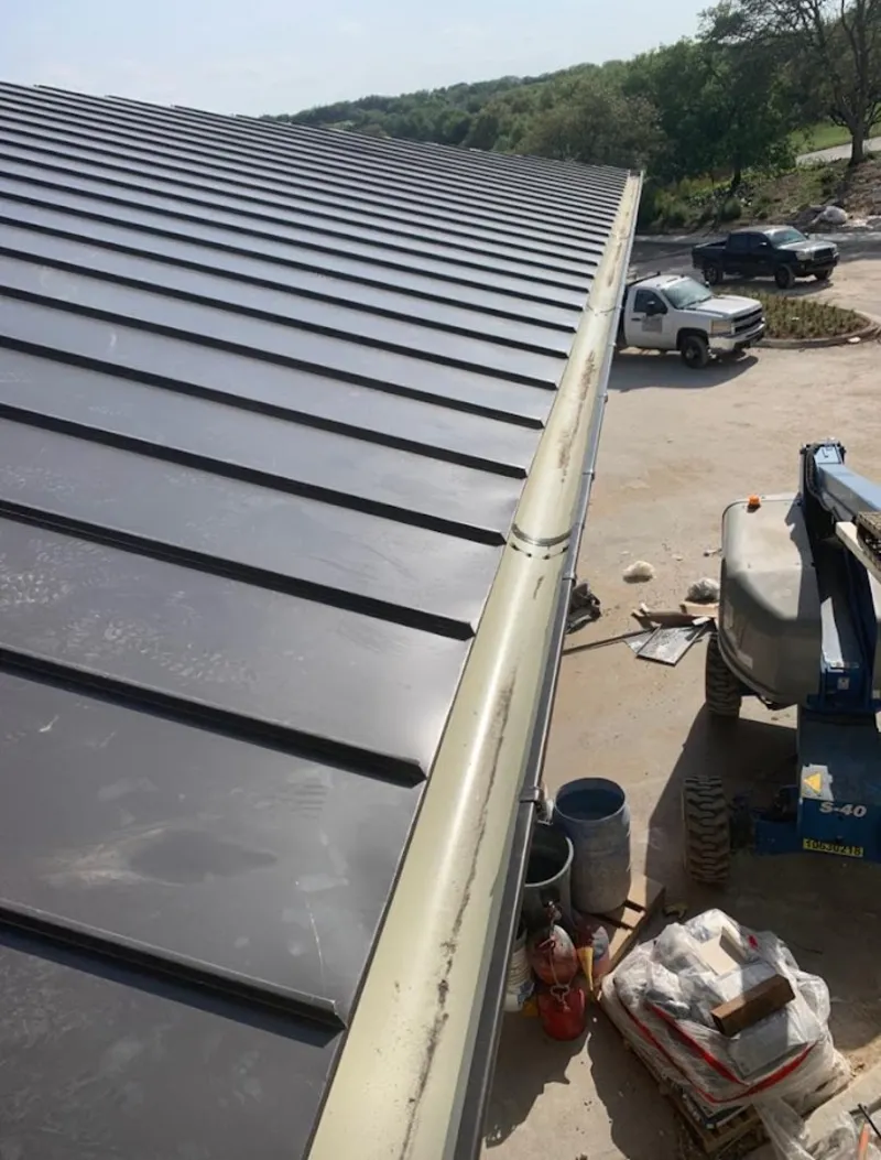 Standing seam panel and gutter detail on a metal roofing jobsite in Hempstead